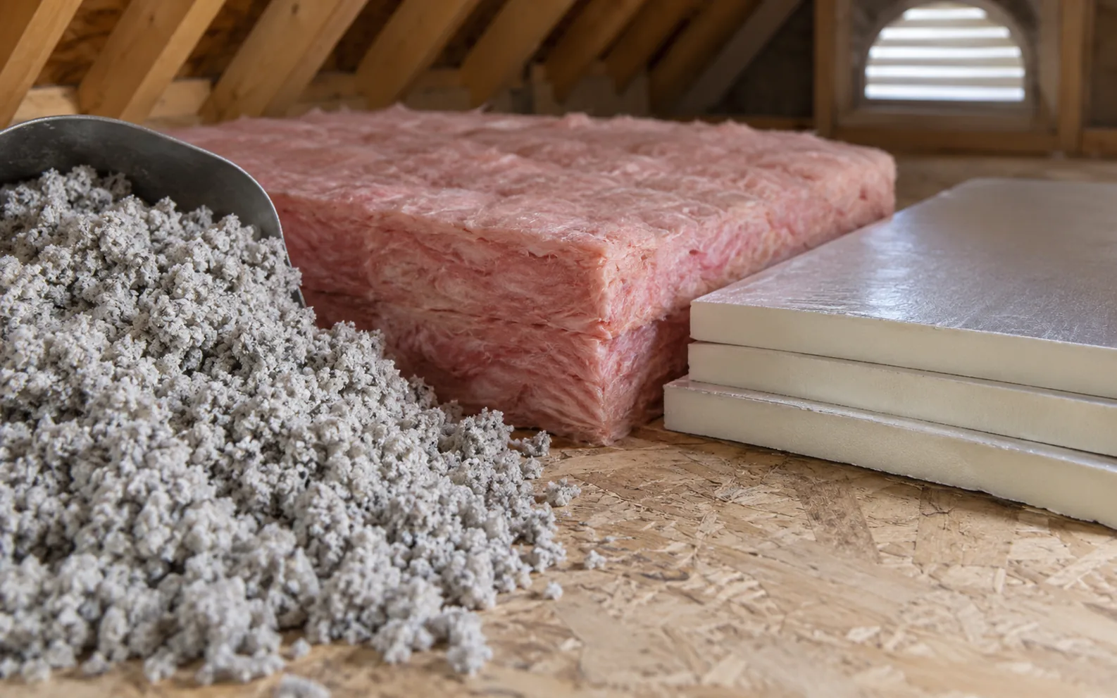 Loose fibres, a fibreglass batt and rigid insulation boards arranged on a work surface.